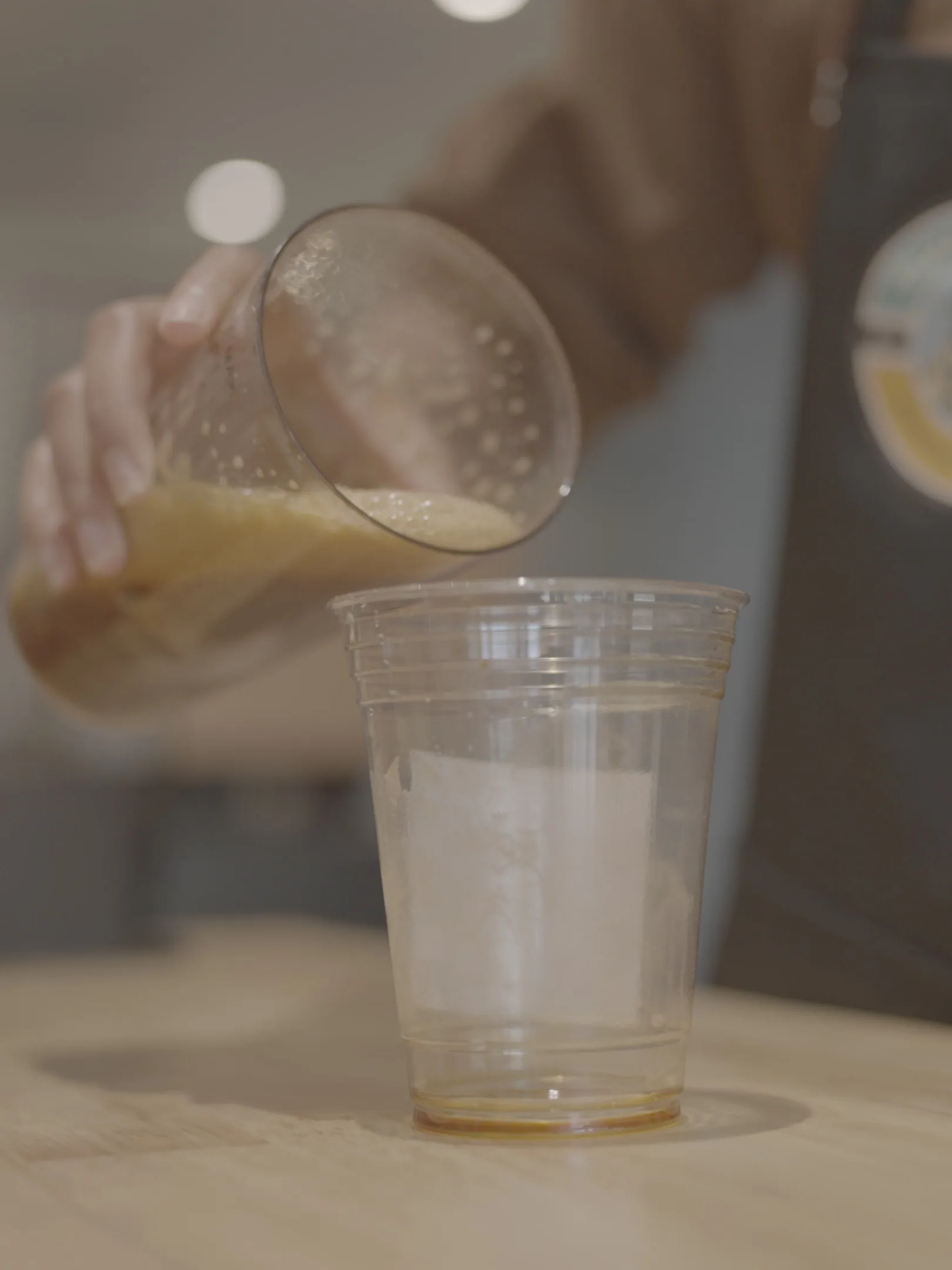 A drink being poured into a cup ahead of service