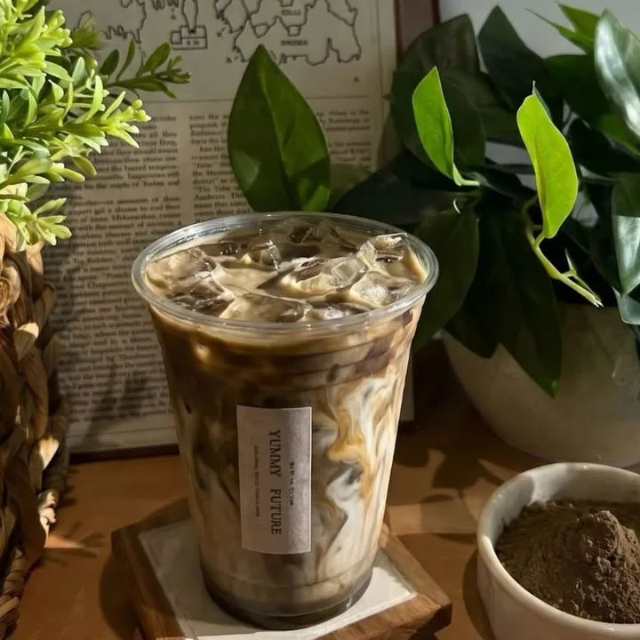 Iced hojicha latte next to a bowl of hojicha powder