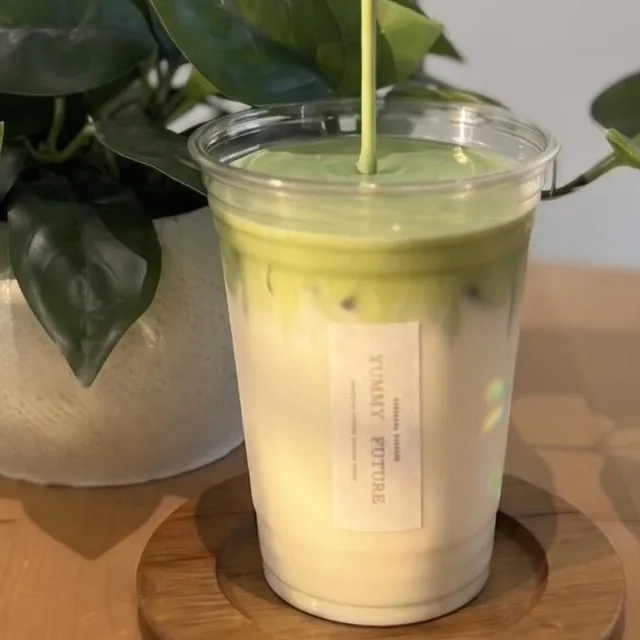 Matcha poured over jasmine tea latte in a clear cup